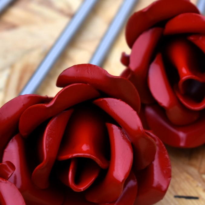 Red painted steel roses closeup