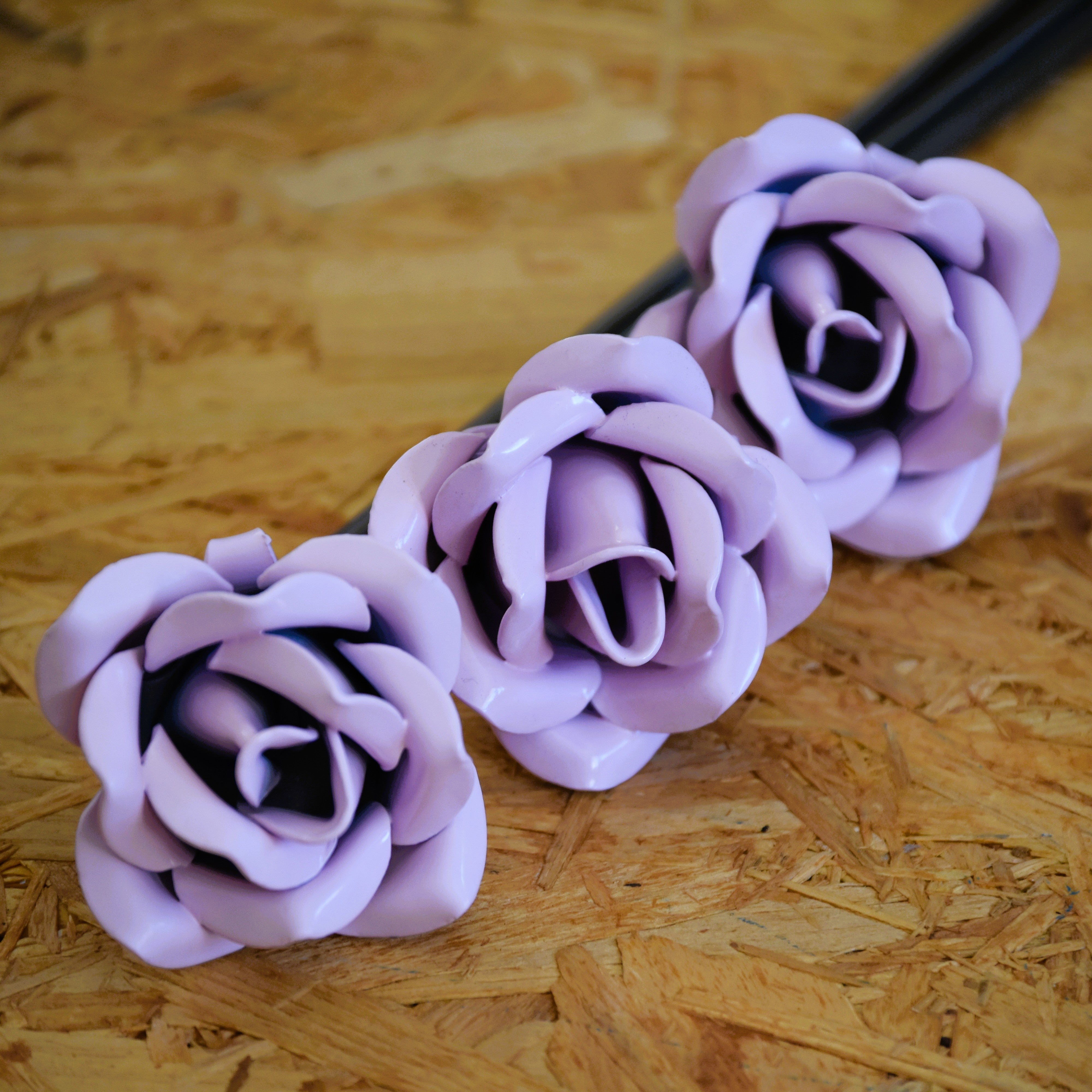 A closeup of three pale pink coloured steel roses