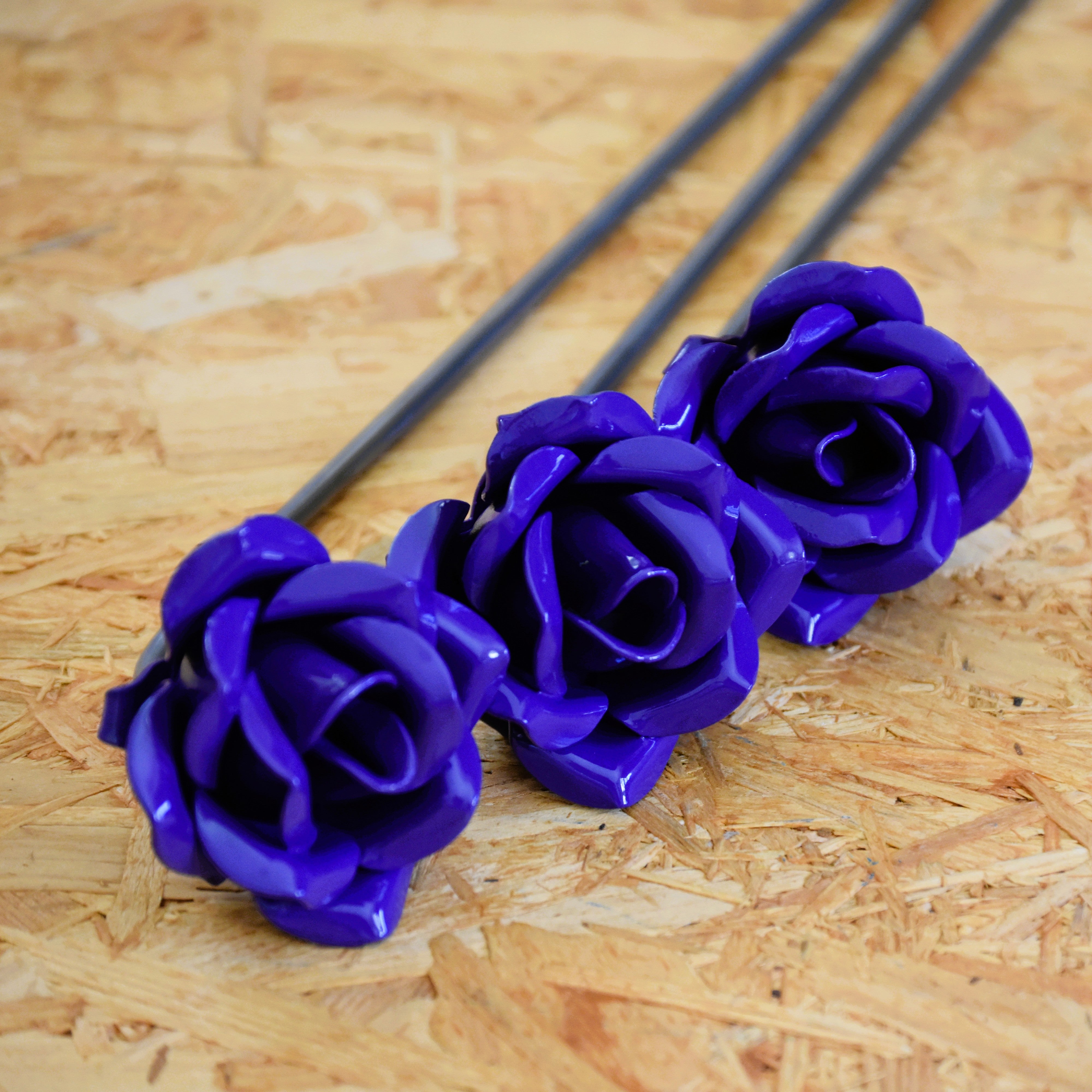 A closeup of three violet coloured steel roses
