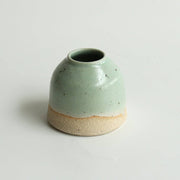 Mini mint green ceramic vase with two-tone glaze on a white background