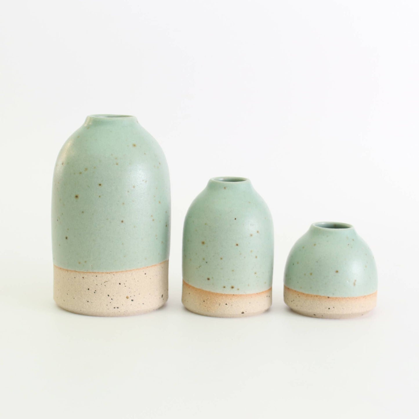 Three mint green ceramic vases of different sizes on a white background