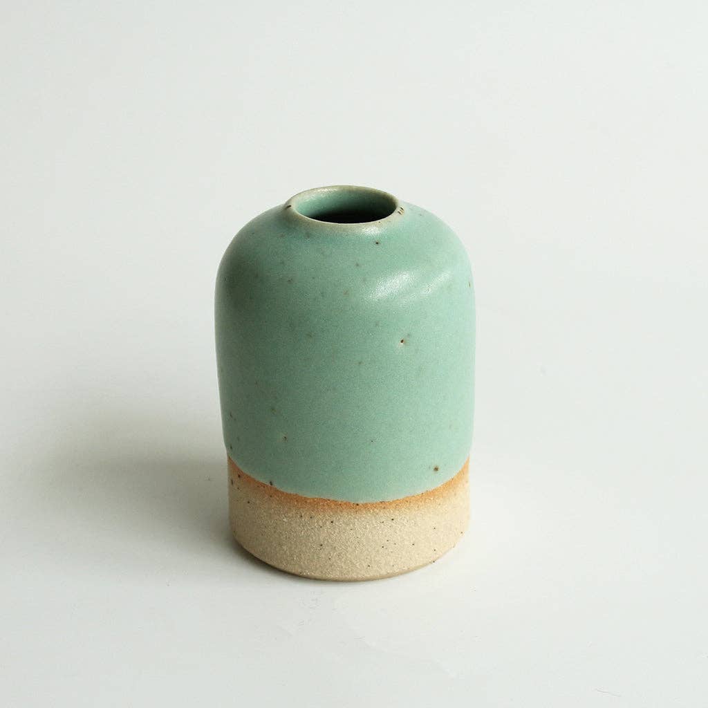 Small mint green ceramic vase on a white background