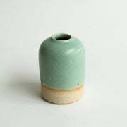 Small mint green ceramic vase on a white background