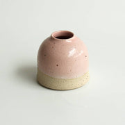 Mini pink ceramic vase on a white background